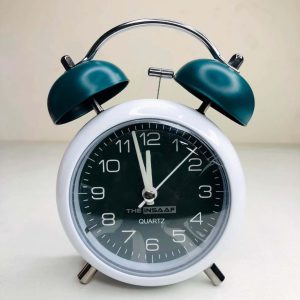 Vintage twin bell alarm clock with teal green bells and black dial
